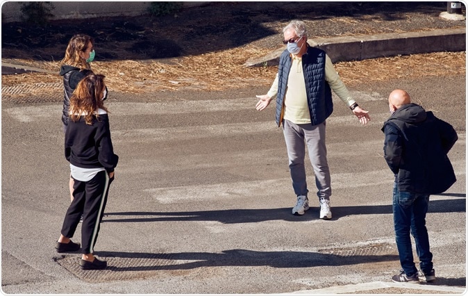 Rome, Italy - April 6, 2020: Four Italian people wearing surgical masks gather outdoors in a residential area, after three weeks of lockdown, Image Credit: Daniele COSSU / Shutterstock