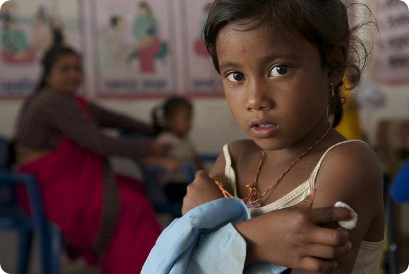 A girl presses a cotton ball against the injection site on her arm after being vaccinated at an immunization site, in Ghermu Village in Lamjung District in Western Region, during the nationwide measles-rubella immunization campaign.