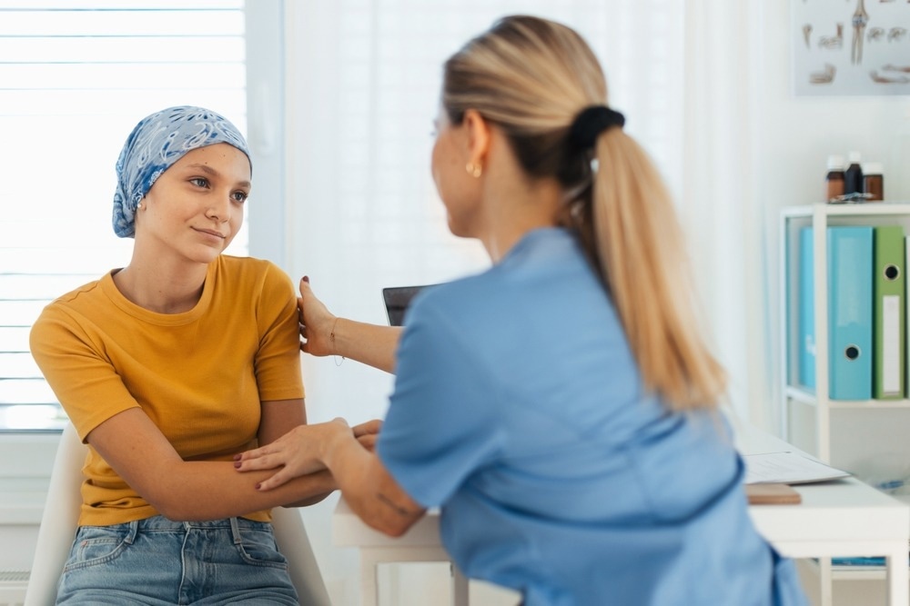 Teenage oncology patient talking with doctor.