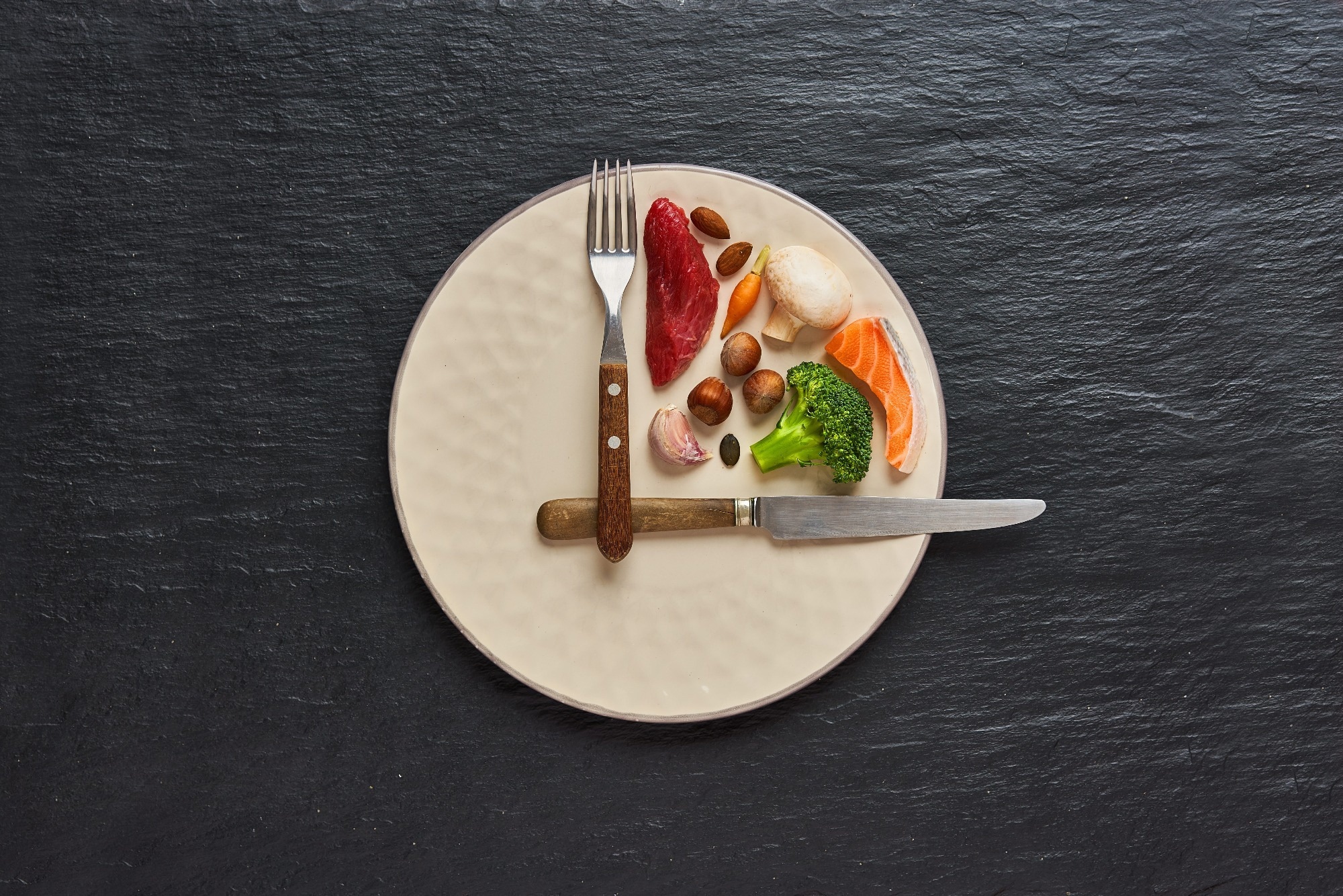 Plate with food and cutlery arranged imitating a clock