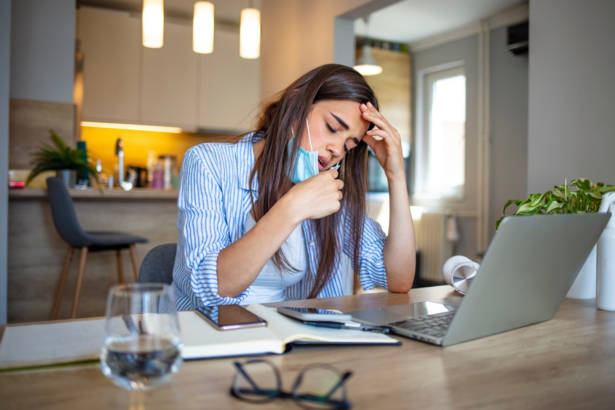 Woman working in the office and having difficulties breathing with face mask
