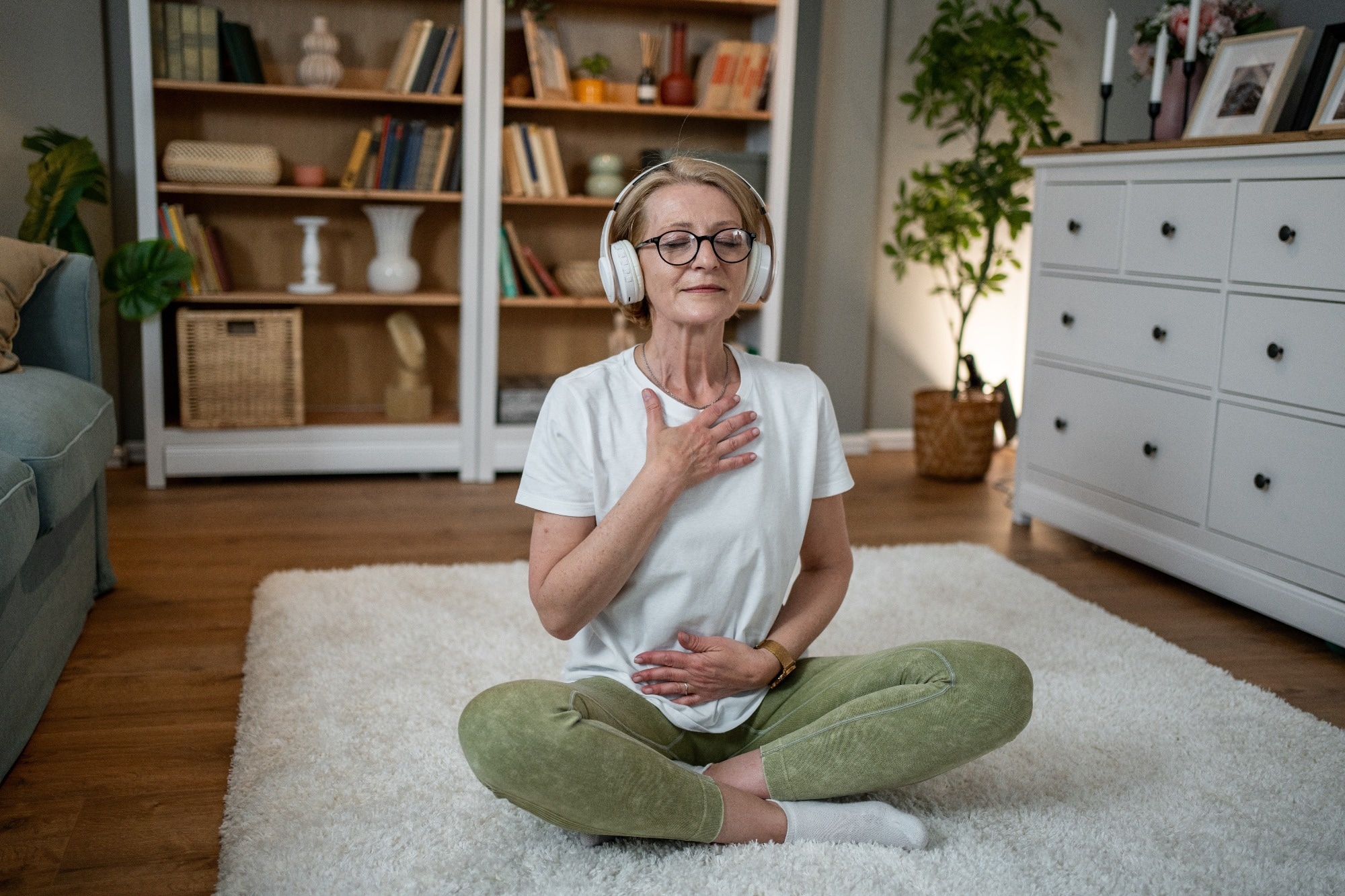 Elderly woman sat on floor doing simple exercise and taking deep breath
