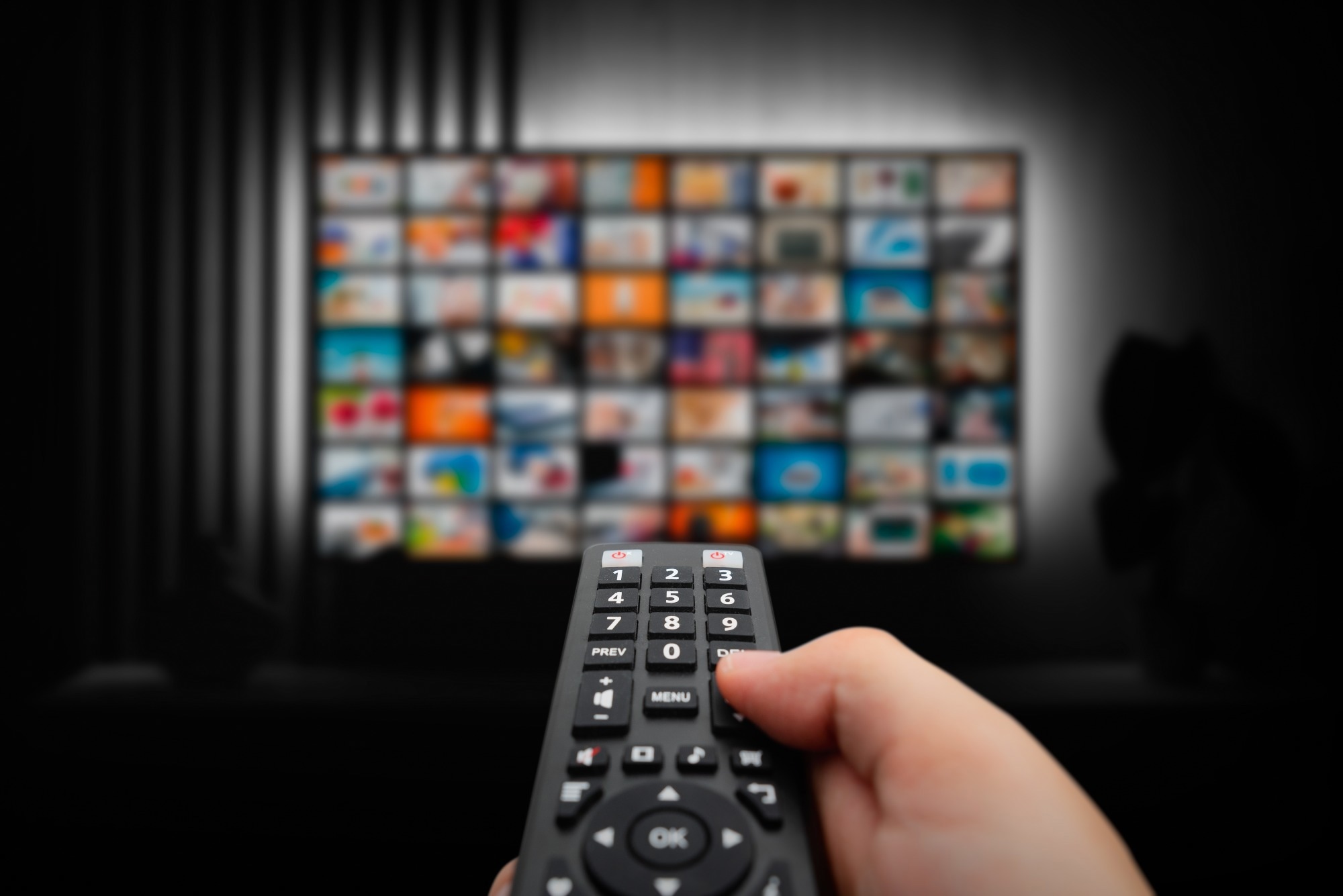 Man watching TV with remote control in hand