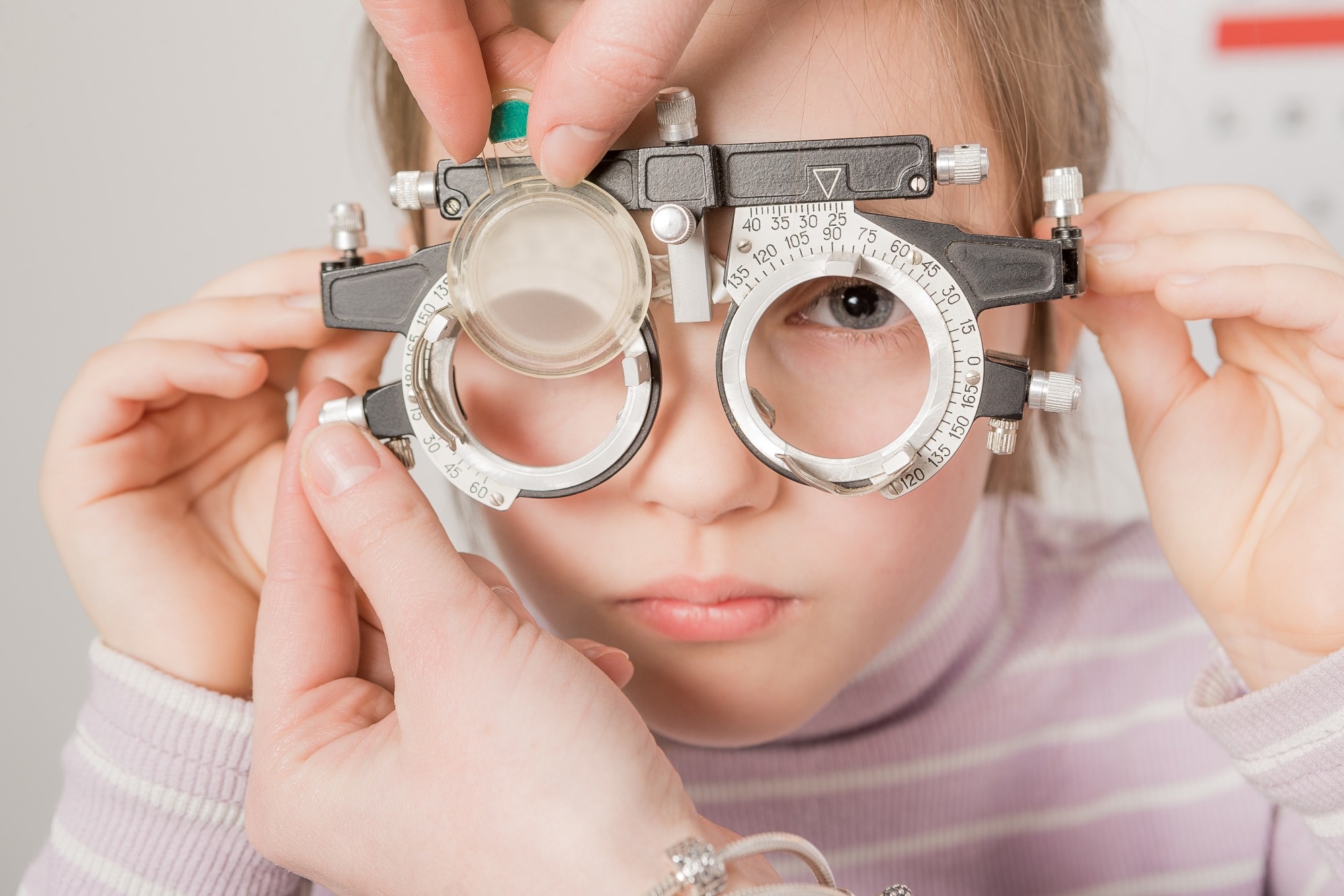 young girl smiling while undergoing eye test
