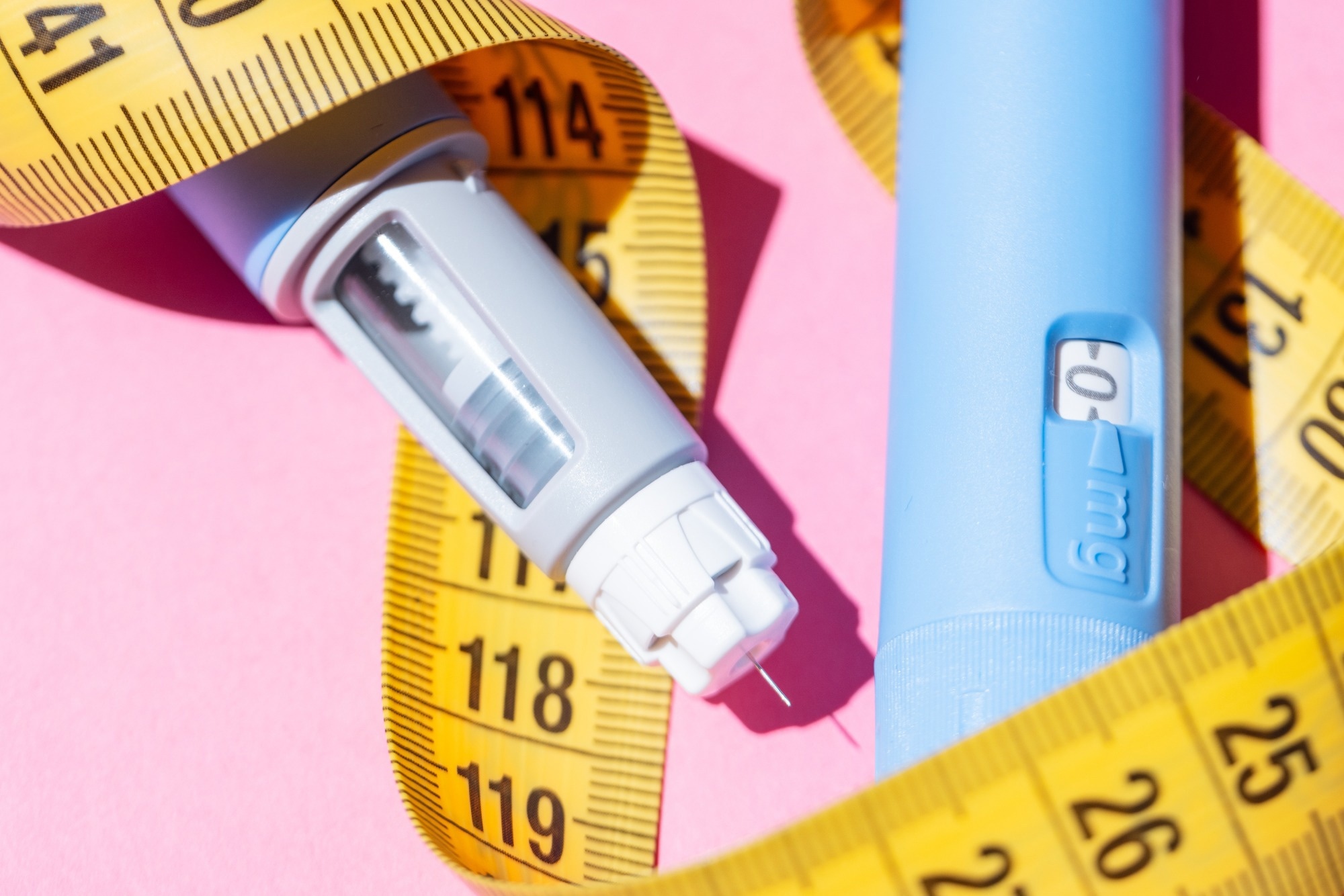 Flat lay of two Ozempic pens on a pink background. Concept of diabetes treatment, weight loss medication, and modern healthcare. Two injectors dosing pens for subcutaneous injection