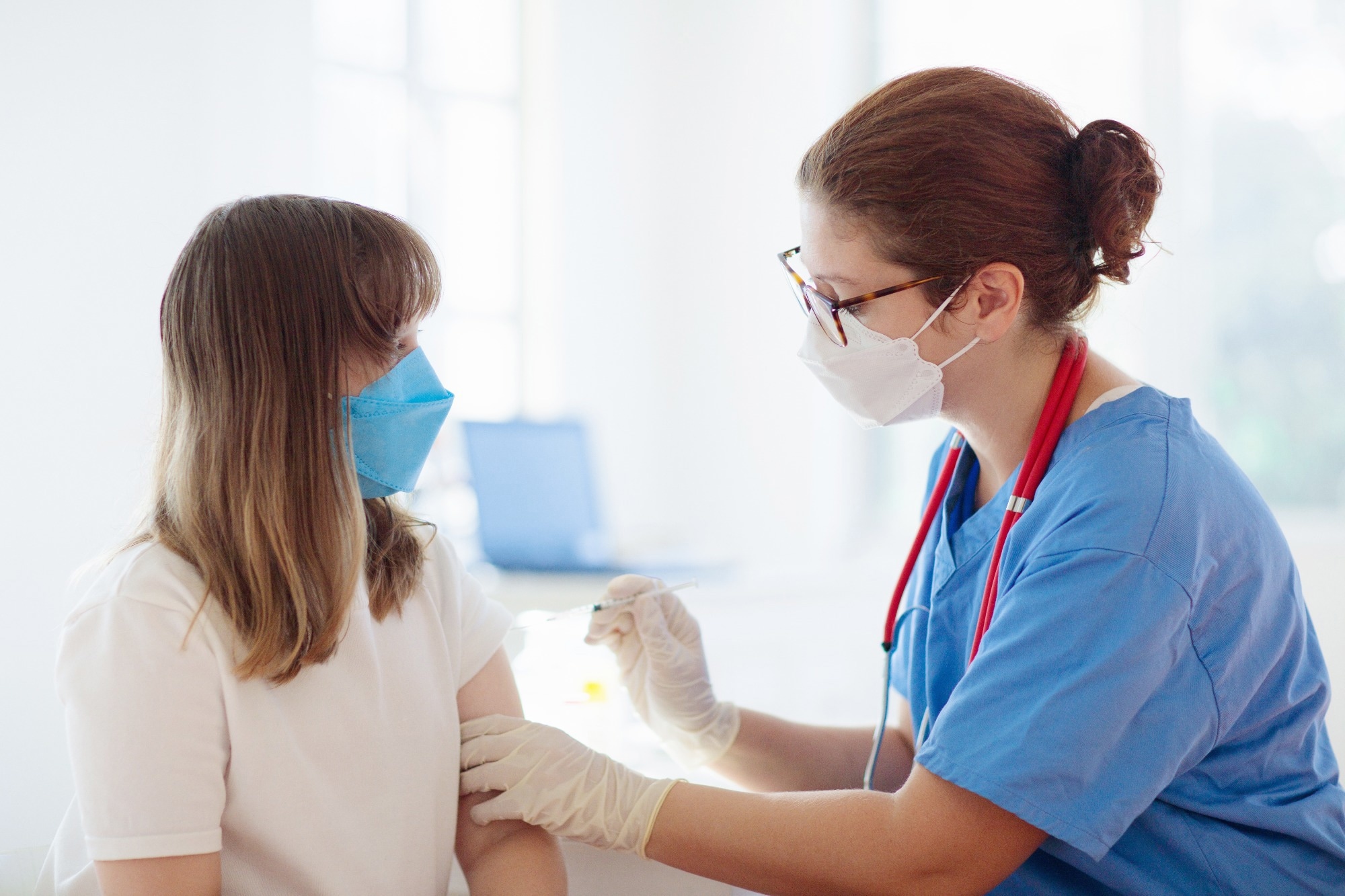 Doctor giving teen girl HPV immunization
